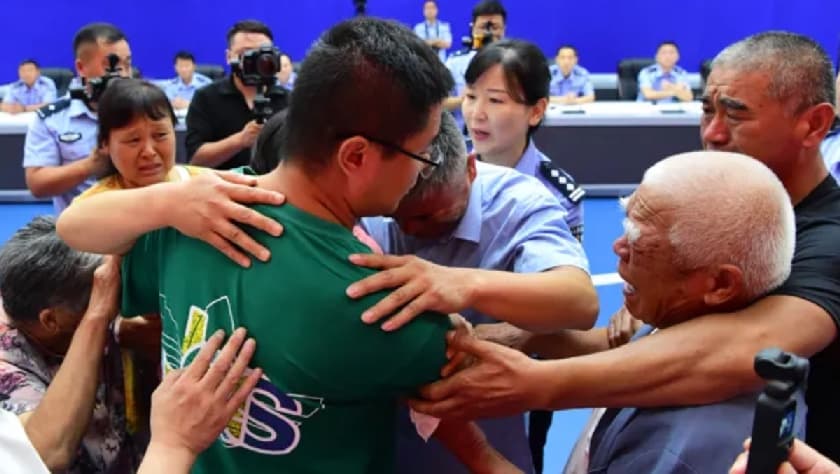 Guo Xinzhen (de verde) es abrazado por su padre (de azul al centro) y sus familiares en la oficina de la policía de Oficina de Seguridad Pública de Liaocheng, en el oeste de China.