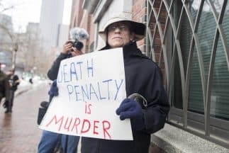 Un hombre protesta contra la pena de muerte en el primer día de juicio contra Dzhokhar Tsarnaev, acusado por el atentado del maratón Boston. 
