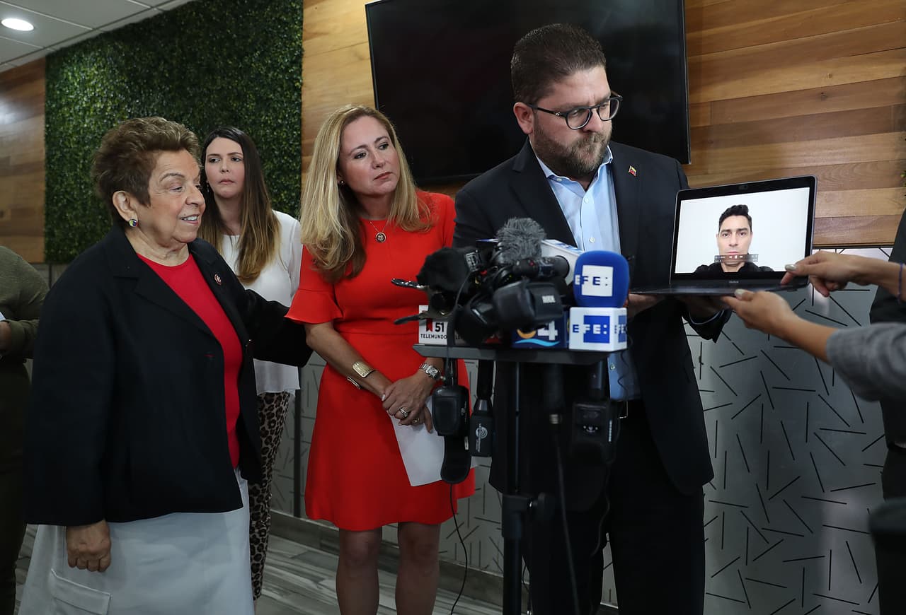Las congresistas Donna Shalala y Debbie Mucarsel-Powell miran el mensaje en video del embajador de Guaidó Carlos Vecchio mientras Gustavo Marcano sostiene la computadora.