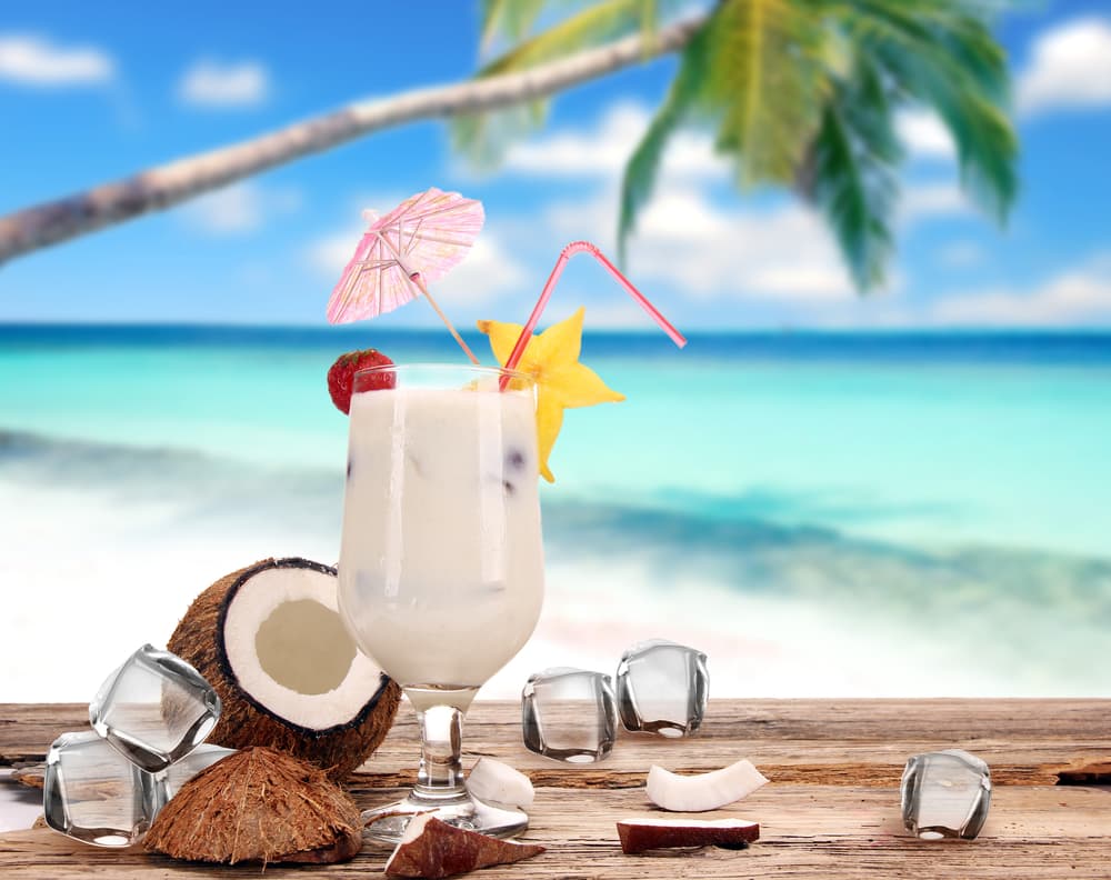 Empieza la preparación vertiendo el hielo, el ron blanco, la crema de coco y rellenar con zumo de piña. Agita bien la mezcla y colar en un vaso. Puedes decorar con rodaja de piña y guinda. Recuerda que para preparar una piña colada sin alcohol, sigue los mismos pasos pero sin añadir ron.