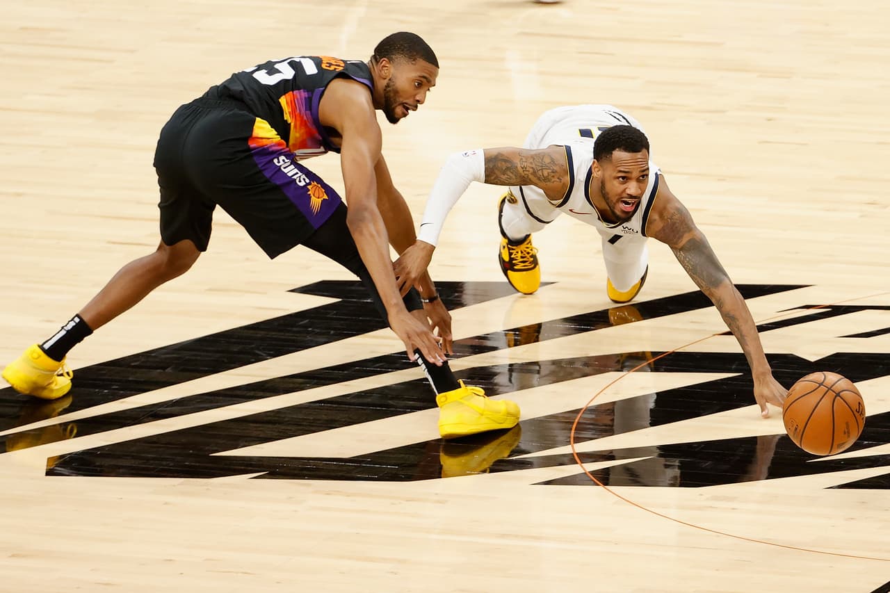 Monte Morris # 11 de los Denver Nuggets y Mikal Bridges # 25 de los Phoenix Suns luchan por un balón suelto durante la primera mitad del juego.