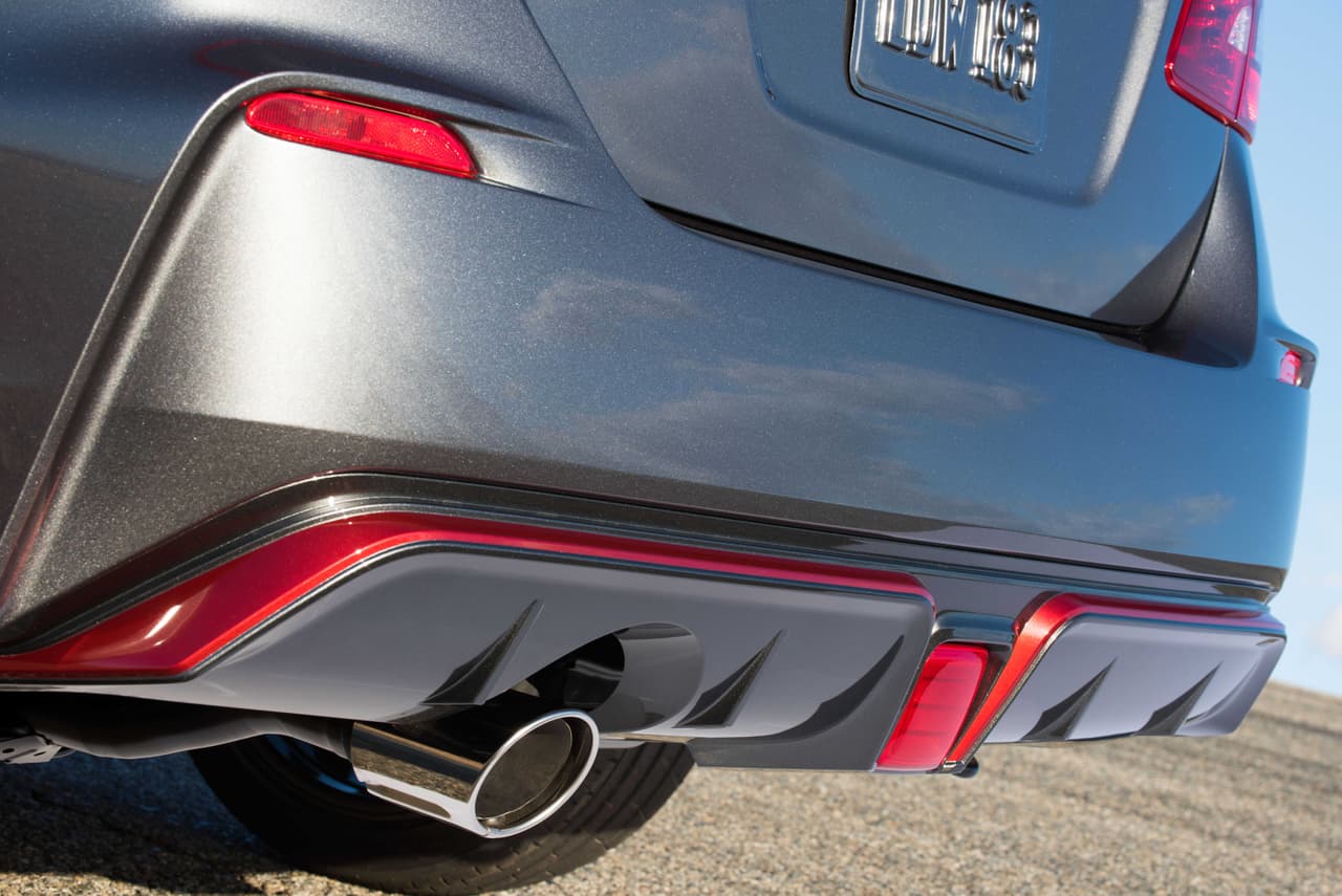 El Nissan Sentra NISMO tiene como 
<b>rasgo distintivo el color rojo en diversas líneas</b> que recorren a lo largo y ancho la carrocería. Casi a la altura del tubo de escape recaen sendas franjas finas en rojo que suben hacia el parachoques.