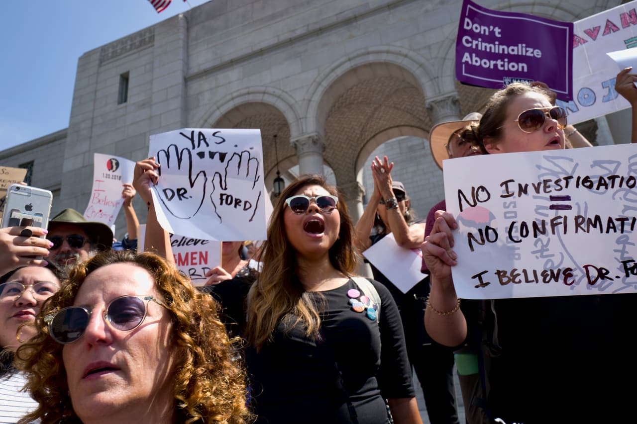 Angry protesters hold signs and chant "Vote Them Out" during an anti Kavanaugh protest outside Los Angeles City Hall on Friday, Sept. 28, 2018. (AP Photo/Richard Vogel)