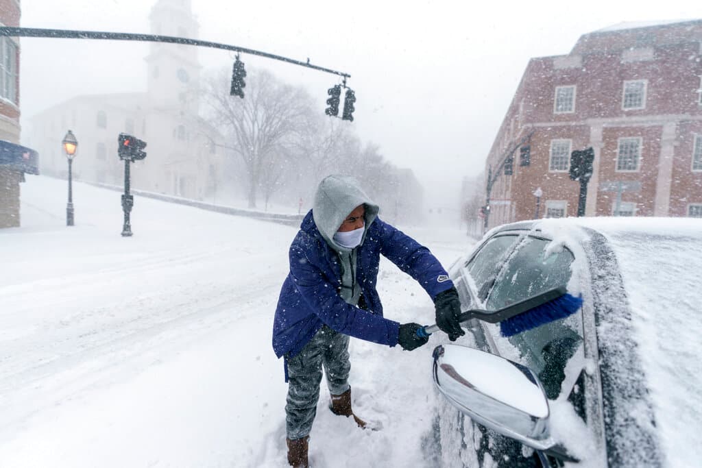 En la foto, Xavier Martínez, en Rhode Island, quita la nieve de su vehículo este sábado.