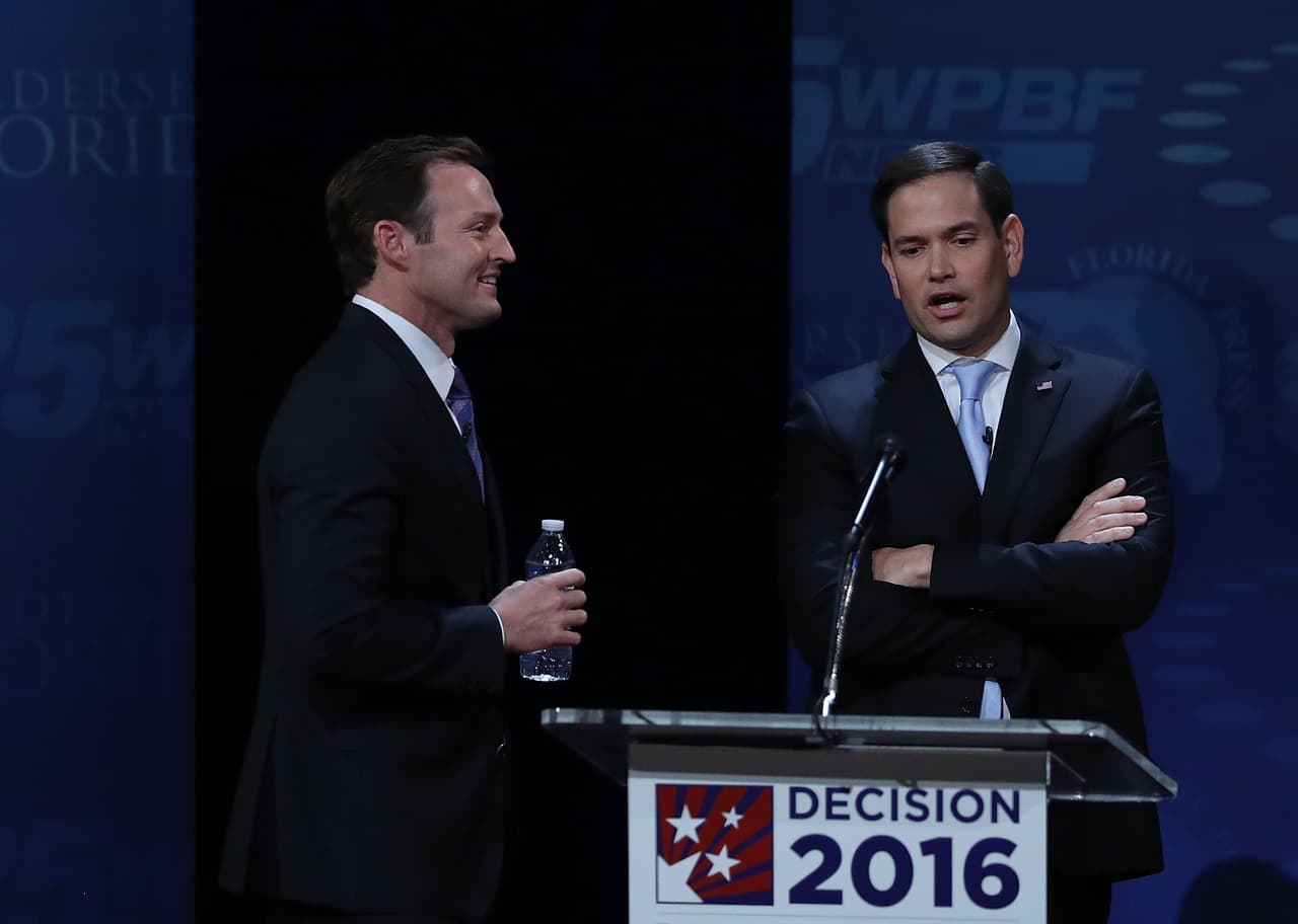Los candidatos a senadores hablan durante un receso en el último debate en Florida, en el Broward College.