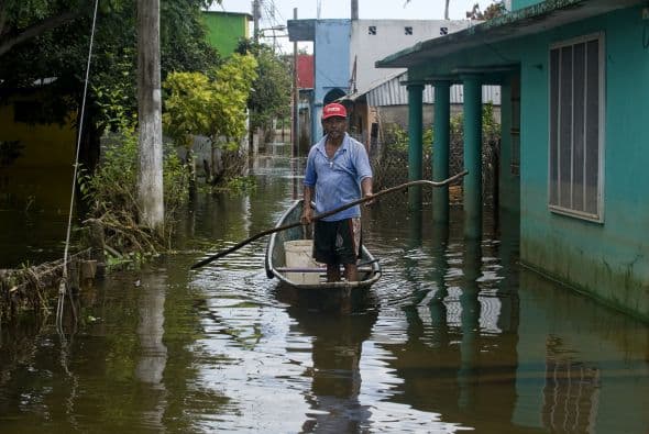 Colgado en una pared del café Colonial invadido por el agua, el cartel con el fondo de la bandera mexicana que invita a "celebrar unidos" ha logrado sobrevir a las inundaciones que obligaron a evacuar a la mayoría de los 8.500 habitantes de Tlacotalpan, el pueblo del compositor de boleros Agustín Lara.