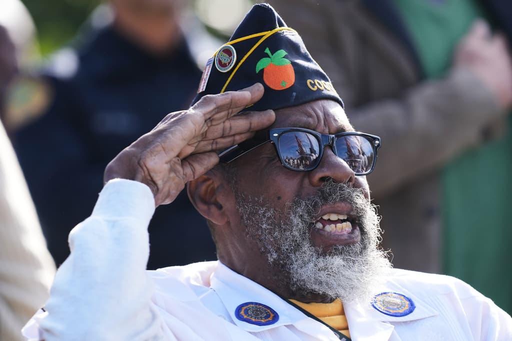El veterano Ronnie Rumph saluda mientras suena el Himno Nacional de EEUU en la celebración del Día de los Veteranos en el cementerio Esther Mae Armbrister Park en Coconut Grove.