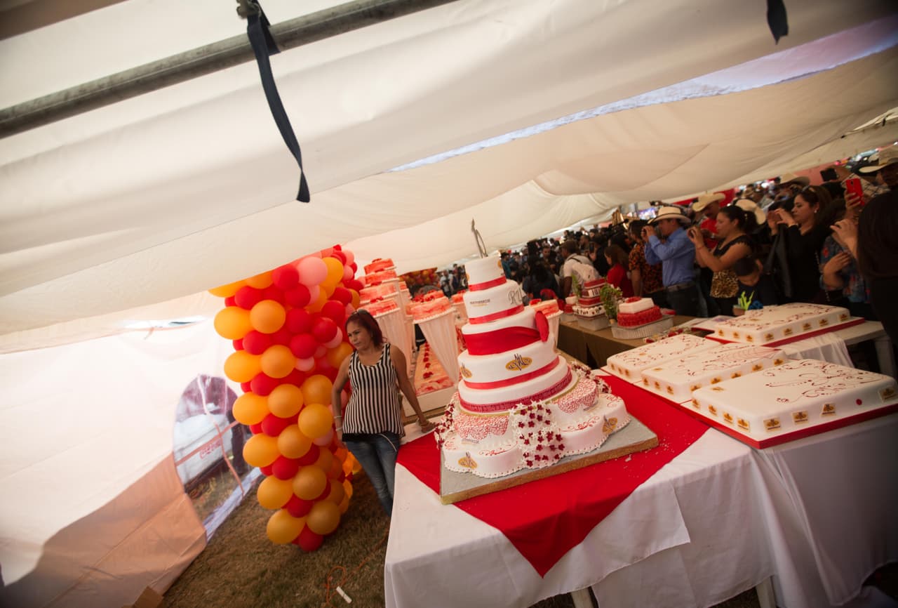 Una mujer se toma una fotografía junto a los pasteles elaborados especialmente para los XV de Rubí.