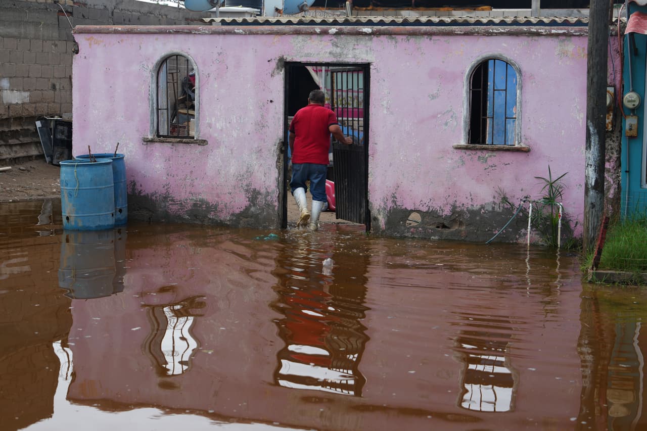 Un residente entra a su casa rodeado de agua provocada por el huracán Polo en Puerto San Carlos, estado de Baja California Sur, México, el martes 29 de septiembre de 2026. (Foto AP/Eduardo Verdugo)