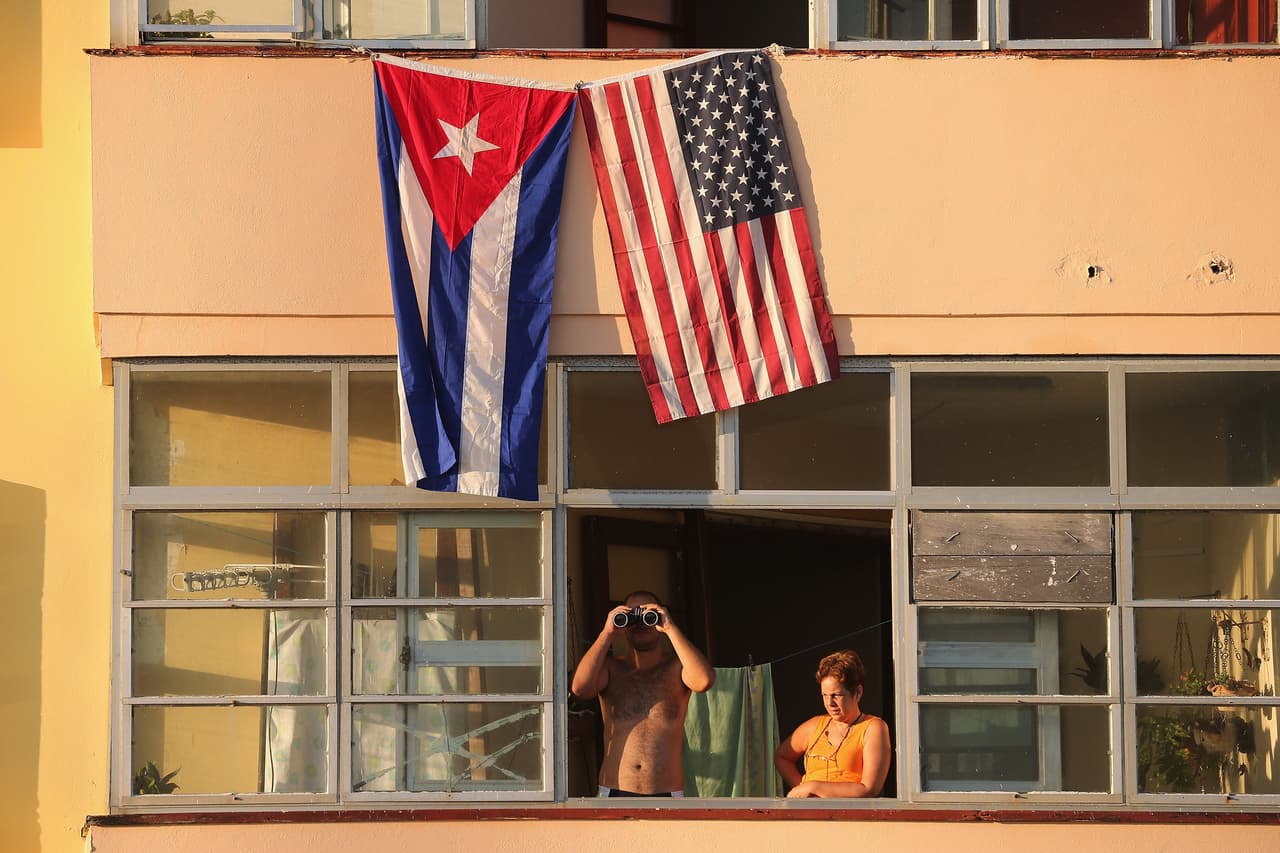 HAVANA, CUBA - AUGUST 14: Cubans look out their window across the street from the newly reopened U.S. Embassy in hopes of watching the flag-raising ceremony August 14, 2015 in Havana, Cuba. The first American secretary of state to visit Cuba since 1945, Secretary of State John Kerry visited the reopened embassy, a symbolic act after the the two former Cold War enemies reestablished diplomatic relations in July. (Photo by Chip Somodevilla/Getty Images)