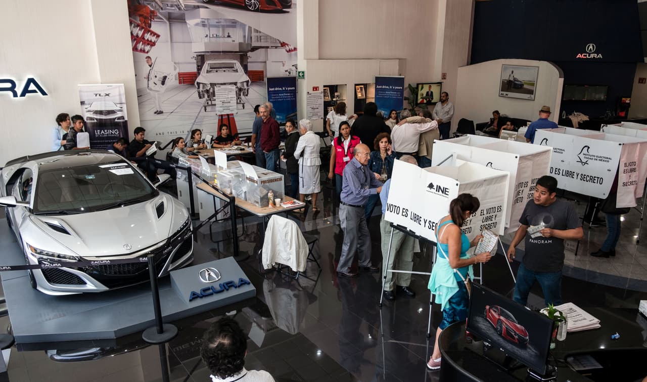 Votantes ejercen su derecho en una casilla instalada en un concesionario de automóviles de lujo en Polanco, Ciudad de México.