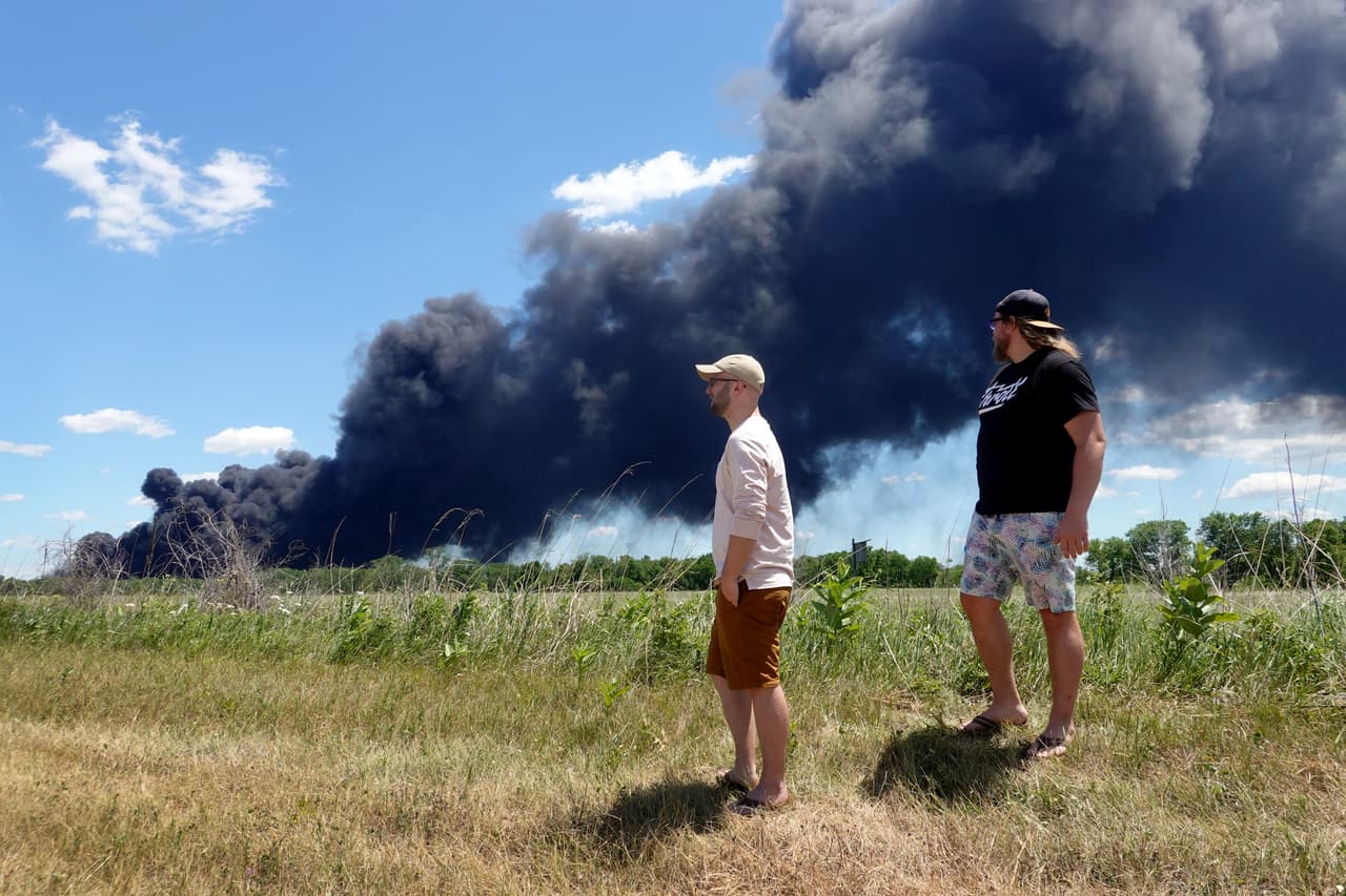 ROCKTON, ILLINOIS.- Logan White (izq.) y Nic Poulisse observan cómo arde un incendio industrial en Chemtool Inc.