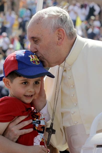El Papa besa a un niño en Ammán, Jordania, un gesto de cariño que se vuelve cotidiano en sus visitas y audiencias públicas.