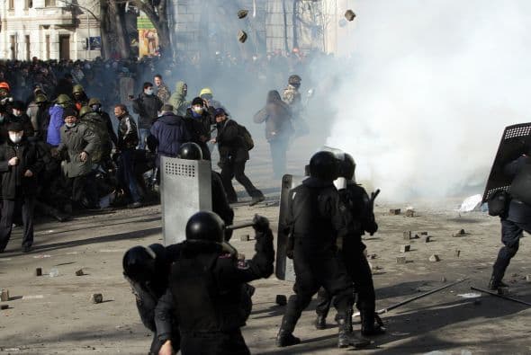 La policía ucraniana cercó hoy a los manifestantes en el corazón de las protestas opositoras de la plaza de la Independencia de Kiev (Maidán), tras una jornada en la que murieron 14 personas en los disturbios que estallaron en la capital. Víktor "Yanukóvich se ha convertido en un presidente sangriento", aseguró hoy el dirigente opositor Vitali Klitschkó en un llamamiento a los países democráticos para que intervengan en Ucrania y frenen la violenta confrontación. Según se acercaba la medianoche, los temidos Berkut, el destacamento antidisturbios, estrechaban el cerco en torno a los miles de manifestantes concentrados en el Euromaidán, bastión de las protestas desde el pasado 21 de noviembre. "Los extremistas de la oposición han cruzado la línea roja; matan a inocentes en la calles de la capital de Ucrania, vejan a mujeres, queman edificios y automóviles. Y si los disturbios continúan, nos veremos obligados a actuar con firmeza", rezaba el ultimátum del Servicio de Seguridad y el Ministerio del Interior de Ucrania. Advierten a los americanos que se queden dentro de las casas y de nuevo se sienten explosiones en la ciudad.