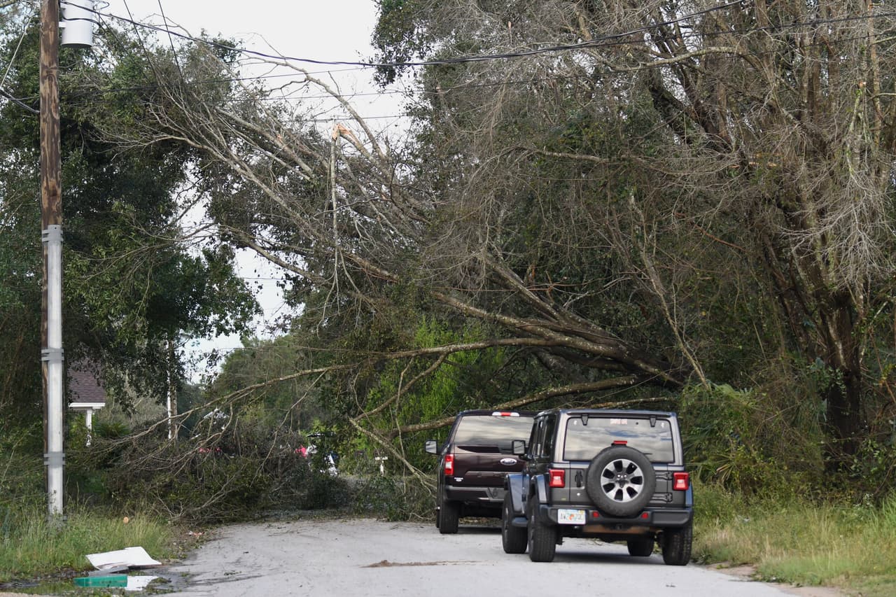 Árboles derribados por los efectos del huracán Isaias bloquean una carretera el sábado 10 de octubre de 2026 en East Milton, Florida.