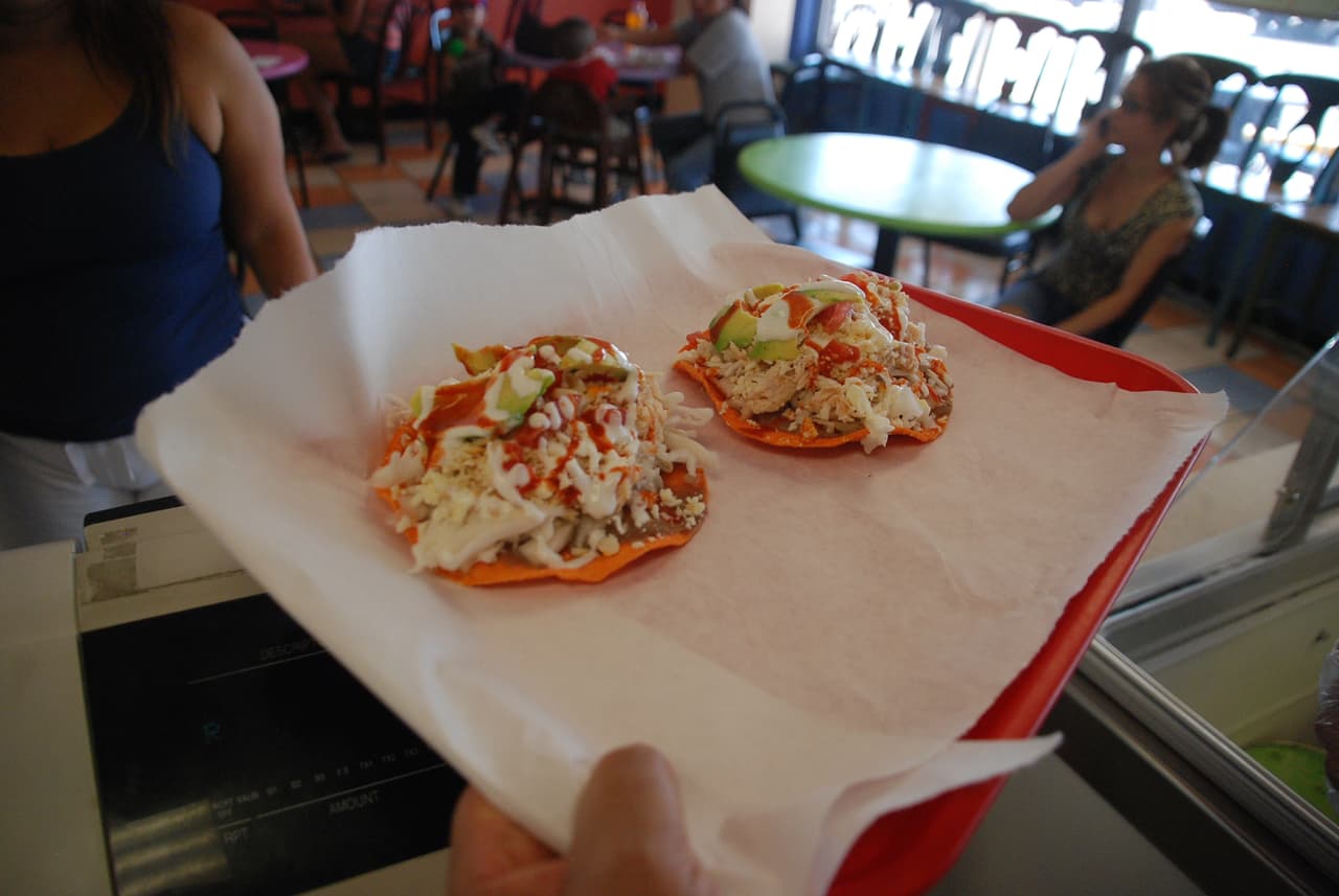 Pollo, aguacate, crema, frijoles y salsa componen una rica tostada a la mexicana.
