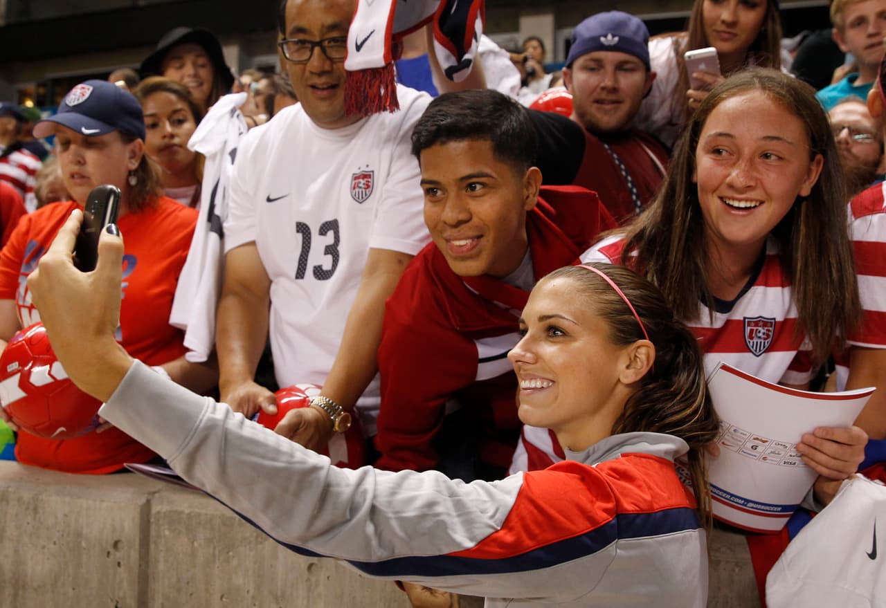 Alex Morgan del equipo de futbol de Estados Unidos, toma selfies con los fans.