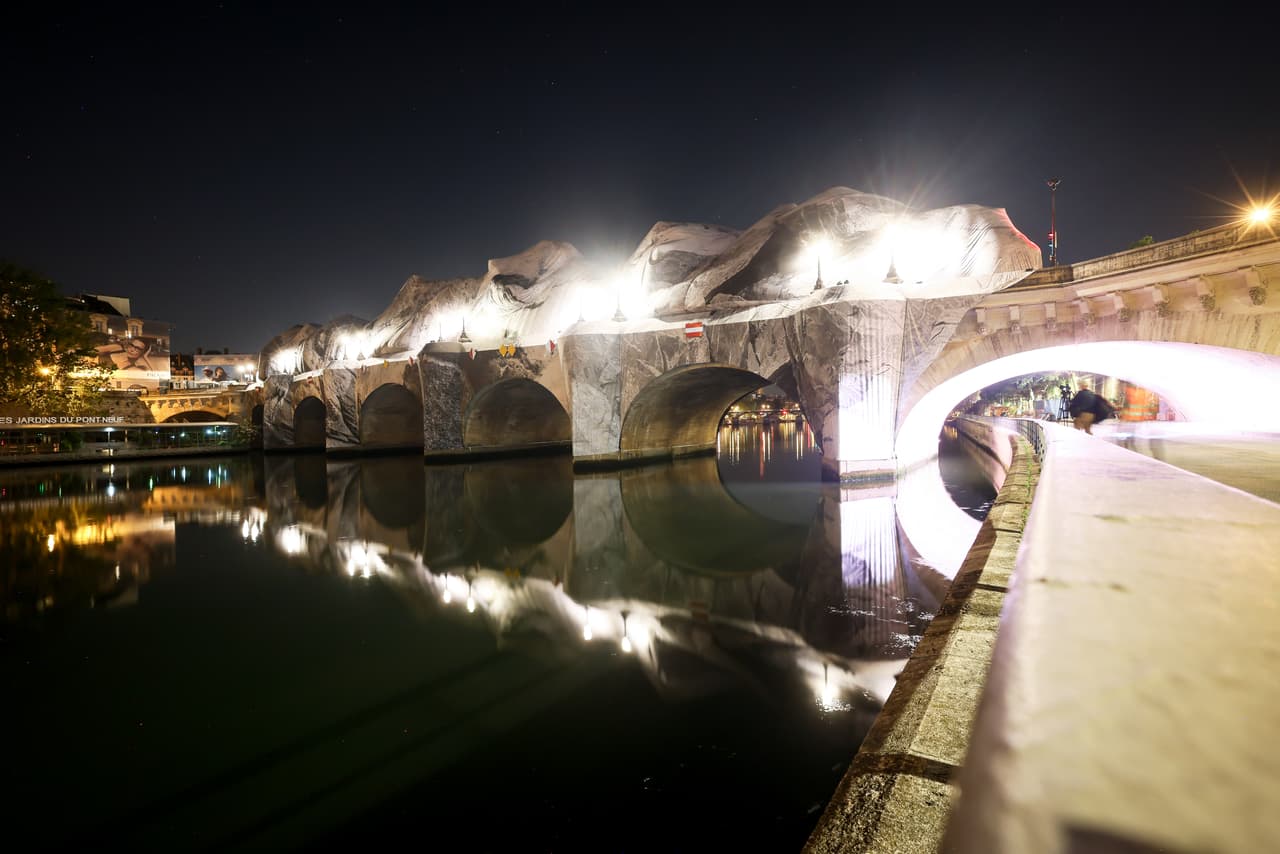 Inflation of the artwork "The Pont Neuf Cave" by French street artist JR on the Pont Neuf bridge, Thursday, May 21, 2026, in Paris, before its free opening to the public from June 6 to 28. (AP Photo/Thomas Padilla)