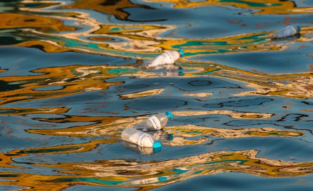 Botellas e plástico con notas dentro flotando en el mar