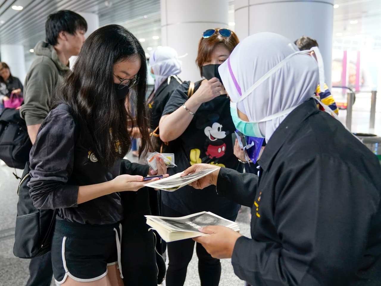 Funcionarios de salud entregan información sobre el coronavirus en el aeropuerto internacional de Kuala Lumpur, Malasia, el martes 21 de enero de 2020. De los 440 casos confirmados al menos menos 260 están en Wuhan, de acuerdo con las autoridades chinas.
