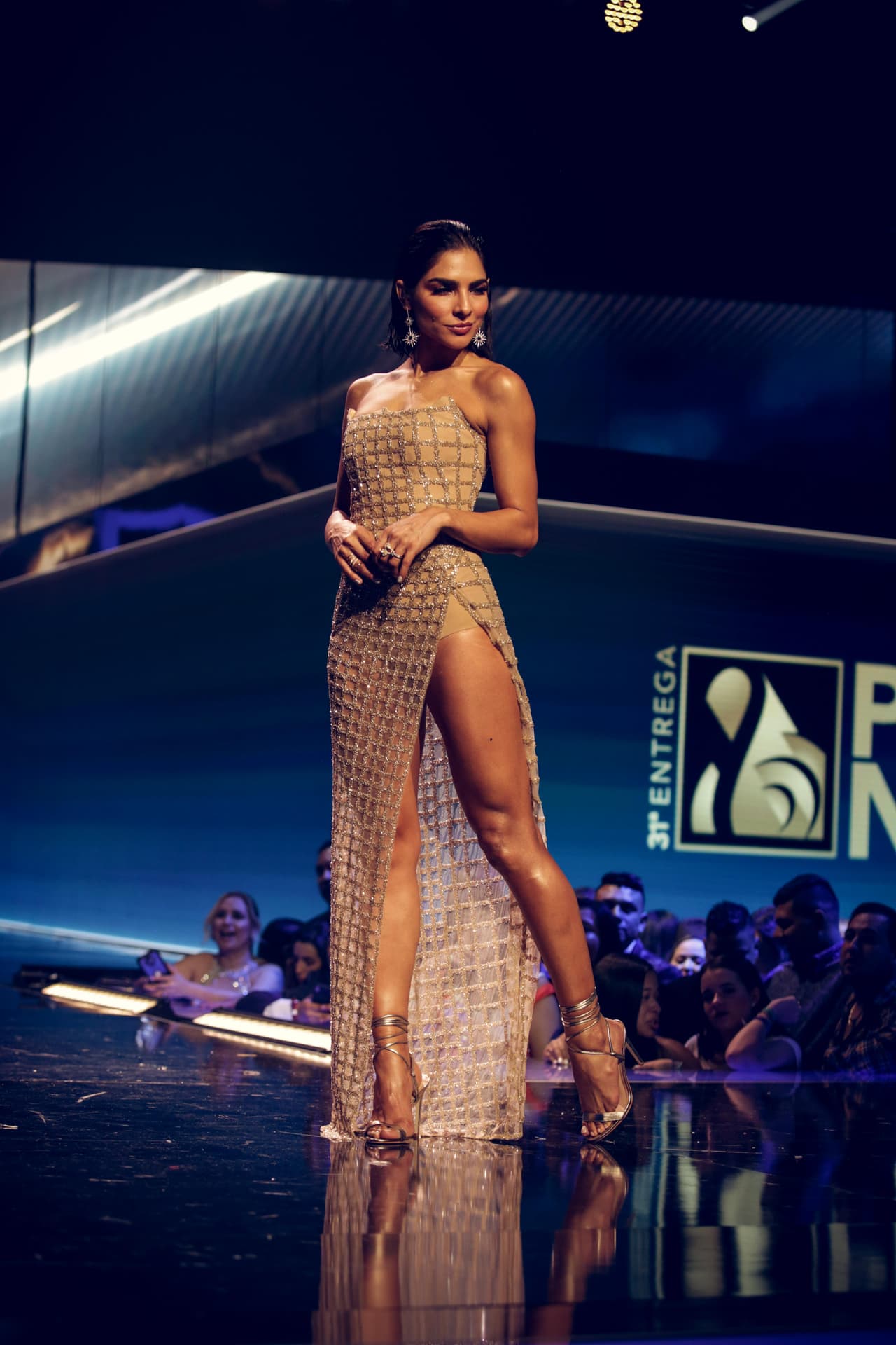 La prenda tenía una profunda abertura en la pierna y escote strapless. Lo acompañó con accesorios metálicos.