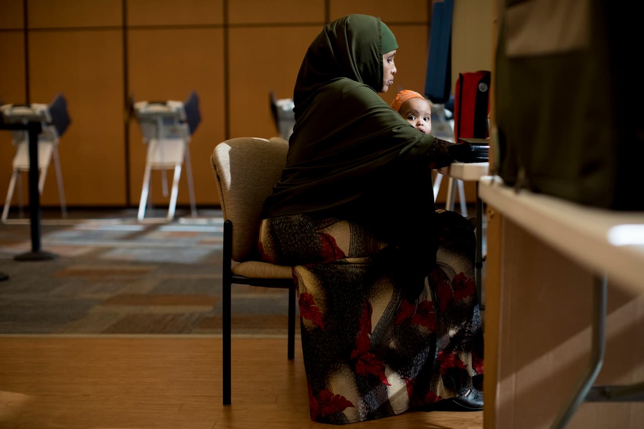 OLATHE, KS - NOVEMBER 08: Khadra Guled holds Mushtaq, her friend's one-year-old daughter, as she prepares to cast her ballot on November 8, 2016 in Olathe, Kansas. After a contentious campaign season, Americans go to the polls today to choose the next president of the United States. (Photo by Whitney Curtis/Getty Images)