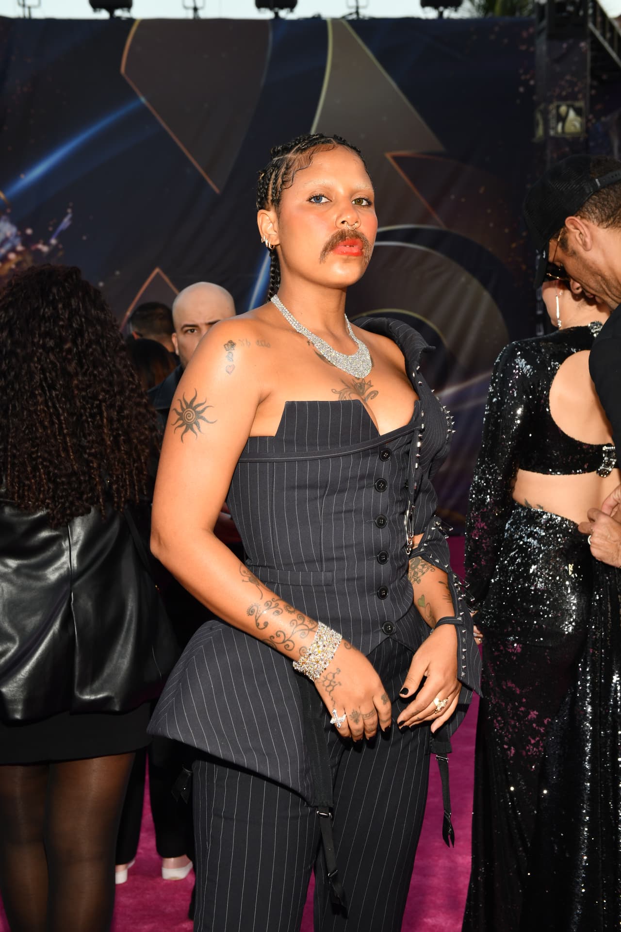 <b>Tokischa</b> arribó con un look original en negro y usando bigote.