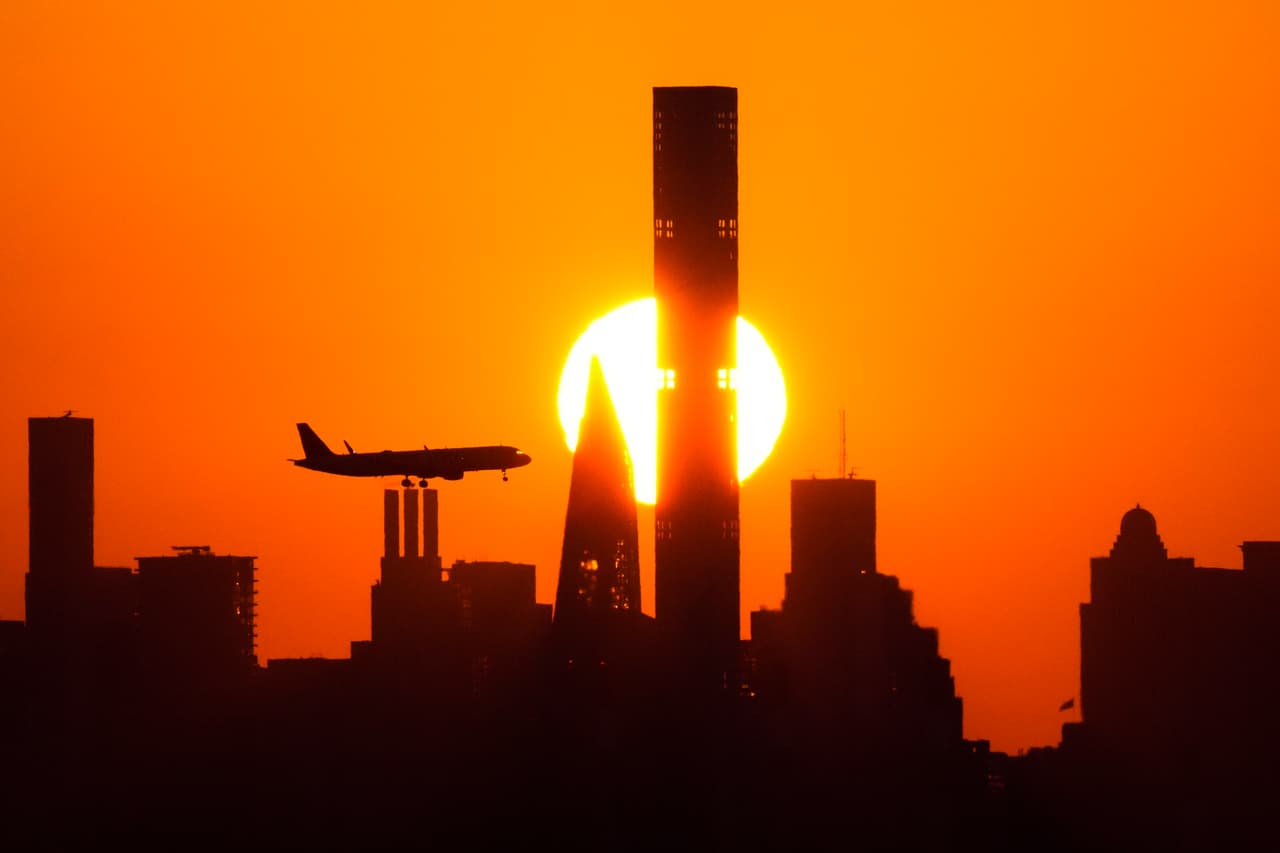 El sol se pone detrás del horizonte de Manhattan mientras el avión se acerca al aeropuerto LaGuardia.