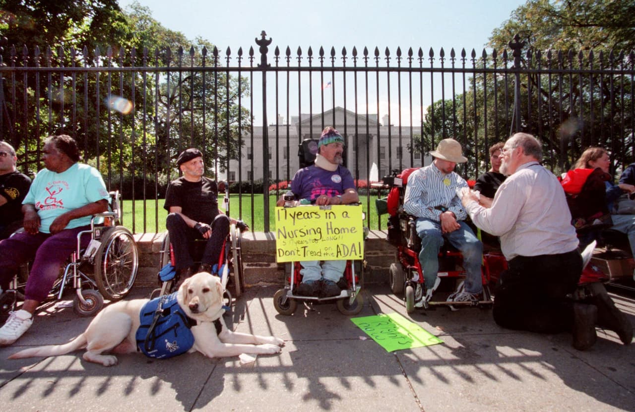 En octubre del año 2000, Denis Jackson y Dan Bayley protestaron frente a la Casa Blanca contra los 
<b>recortes en el financiamiento a los servicios de atención médica en el hogar</b>.
