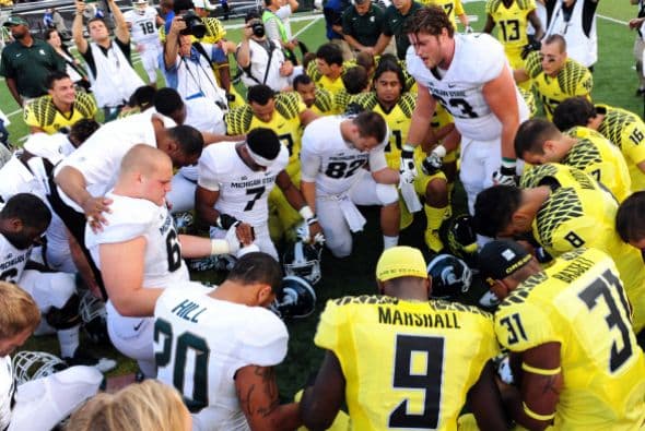 El jugador ofensivo Travis Jackson de los Michigan State Spartans lleva a los jugadores en una oración después de un partido en el estadio Autzen el 6 de septiembre de 2014 en Eugene, Oregon.