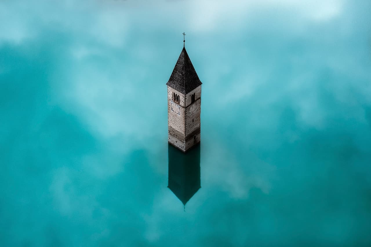 La torre de una iglesia del siglo XIV en Italia permanece sumergida en un lago artificial cerca de Curon Venosta, debido a la construcción de una represa en 1950.
<br>