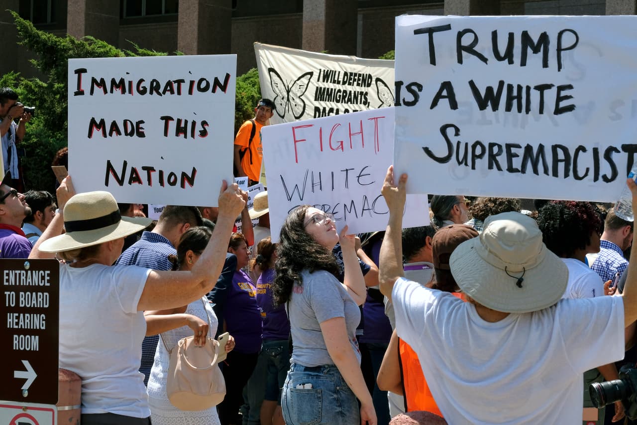 "La inmigración hizo a este país", resalta la pancarta de una activista. "Trump es un supremacista blanca", indica otro cartel.