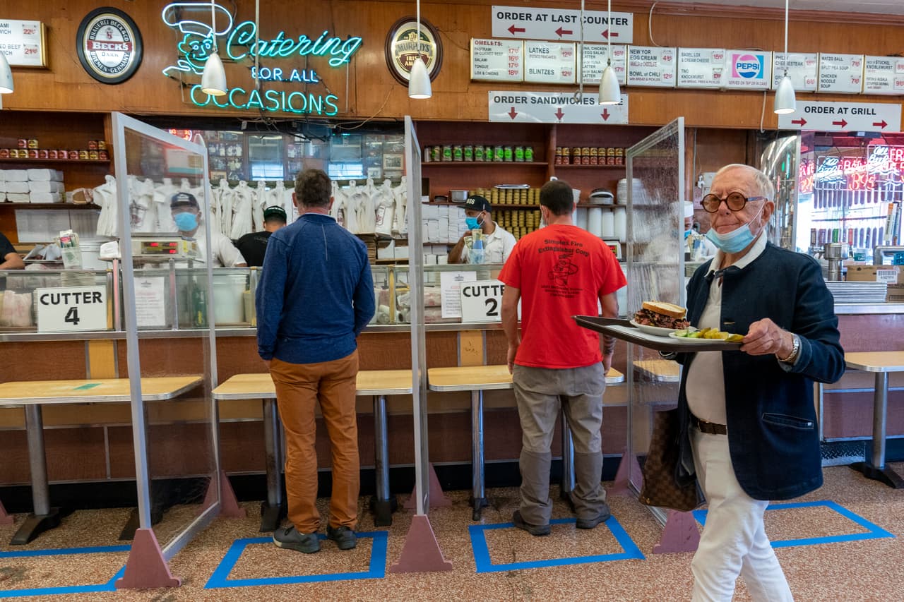 Los clientes hacen sus pedidos en estaciones socialmente distantes en el icónico restaurante Katz's Delicatessen.