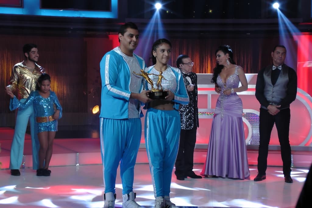 Le entregan un trofeo a las parejas ganadoras.