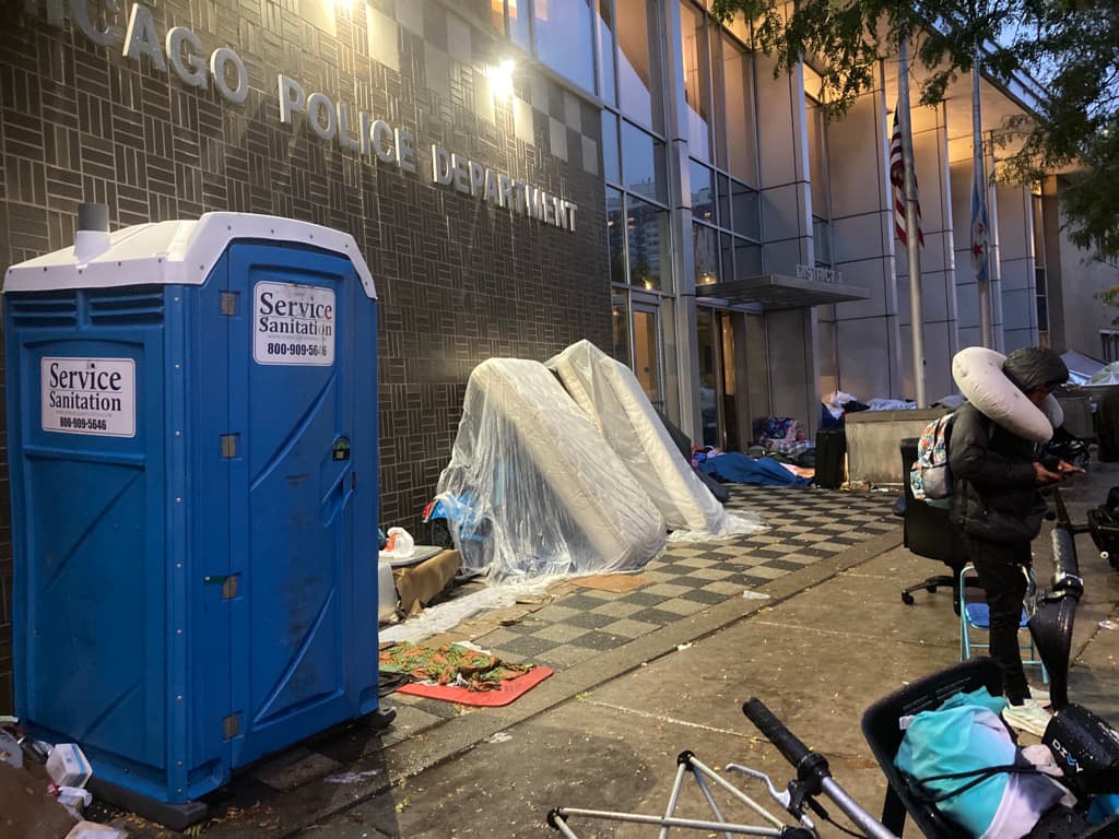 La ciudad colocó baños portátiles fuera de las estaciones de policía para los migrantes.