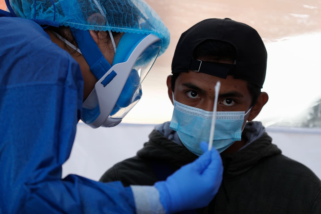 Una doctora le explica a un paciente que recolectará hisopos nasales y de garganta, durante una prueba covid-19 en una tienda de diagnóstico móvil, en San Gregorio Atlapulco, en el distrito de Xochimilco de la Ciudad de México.