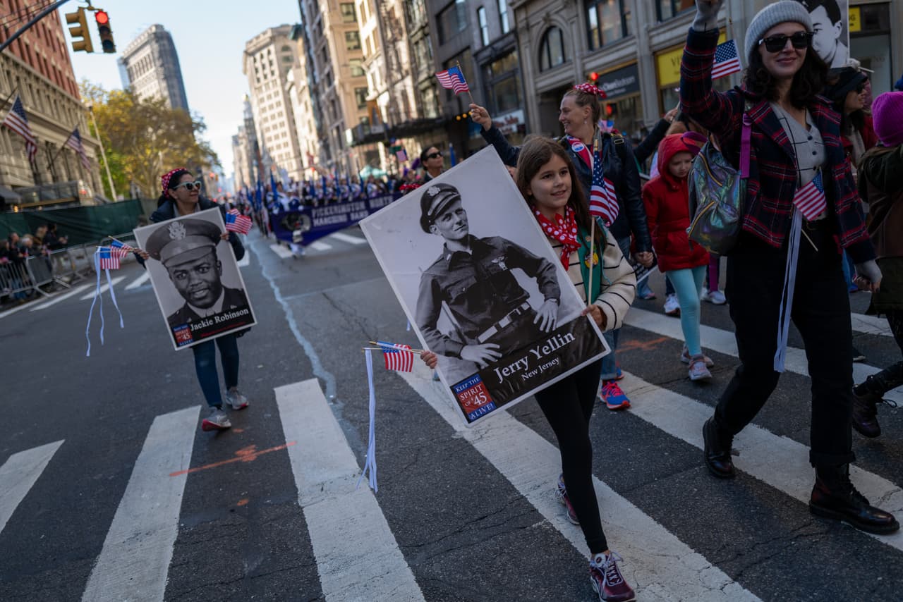 Niños sostienen fotografías de familiares que han prestado servicio para luchar por la libertad y los valores de la democracia occidental, el sistema que más respeta los Derechos Humanos en el mundo.
