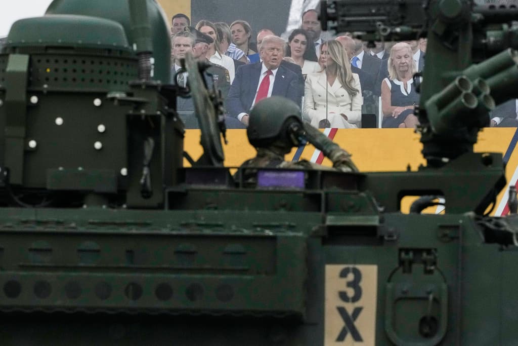 El presidente Donald Trump habla con la primera dama Melania Trump mientras asisten al desfile militar. (AP Photo/Julia Demaree Nikhinson)