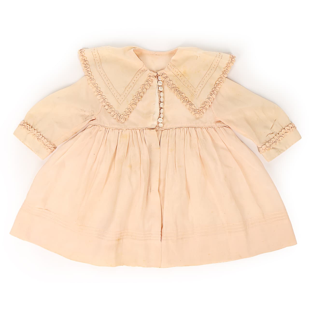 Una de las piezas más importantes de la subasta, este abrigo de seda rosado valorado en unos 3,000 dólares, lo estrenó la entonces princesa 
<b><a href="https://www.univision.com/entretenimiento/realeza/muere-uno-de-los-corgis-de-la-reina-isabel-ii">Isabel II</a></b> en el 1927 cuando era una bebita. Todavía no había cumplido su primer año.