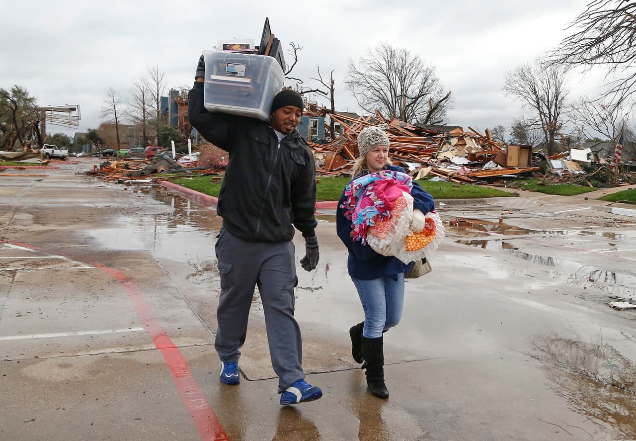 Ronnell Lincoln, de 35 años, y Terri Fykora, de 29, cargan las pertenencias que pudieron salvar tras el paso de los tornados en Texas.