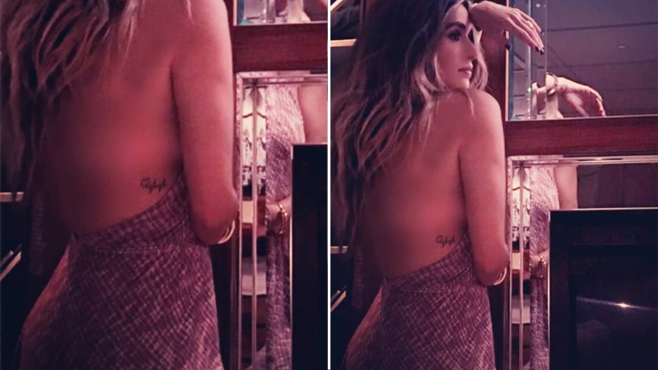 El tatuaje de un electrocardiograma adorna su lado derecho.