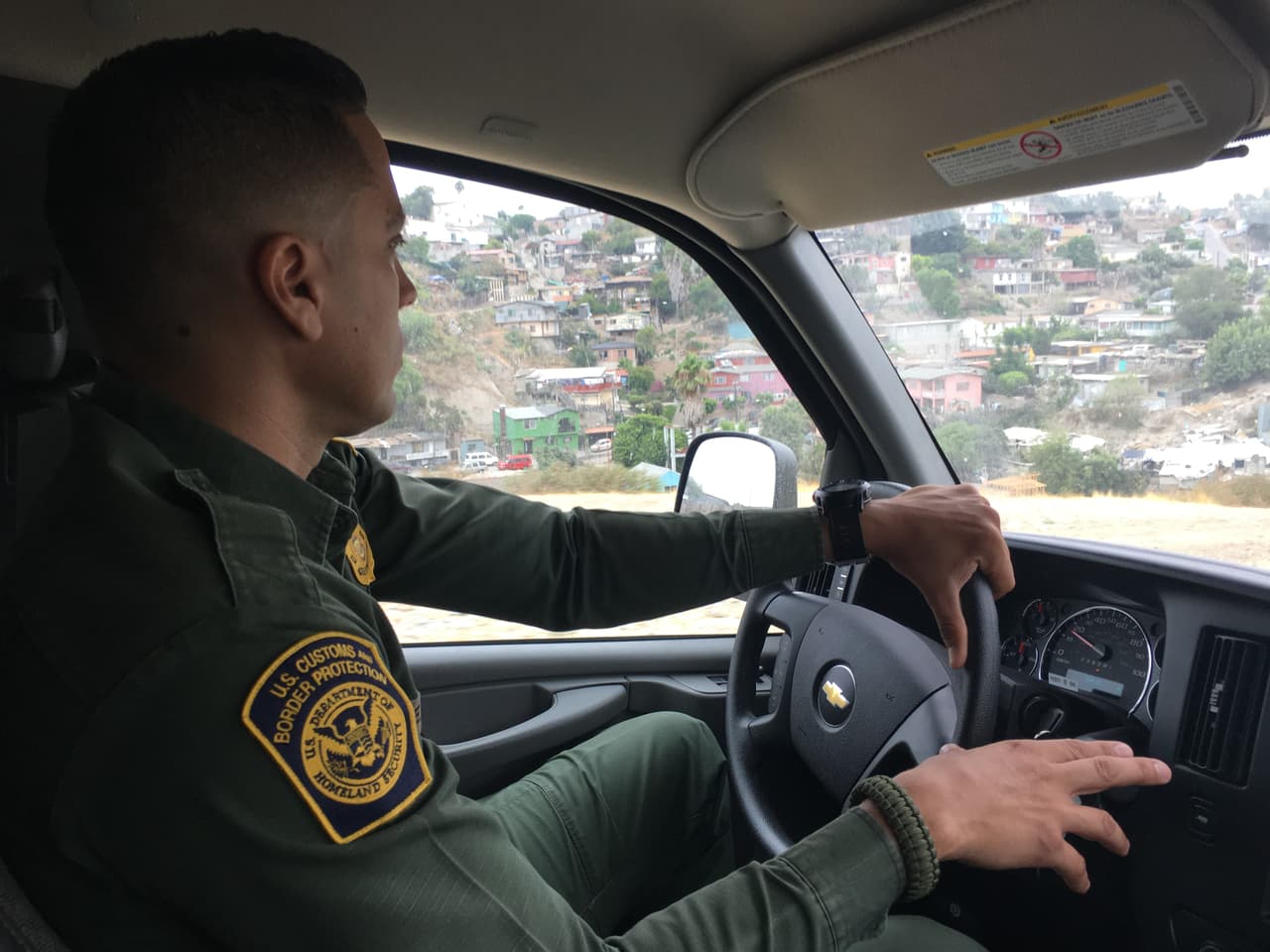 El agente fronterizo Eduardo Olmos conduce junto a la colonia Libertad de Tijuana, México.