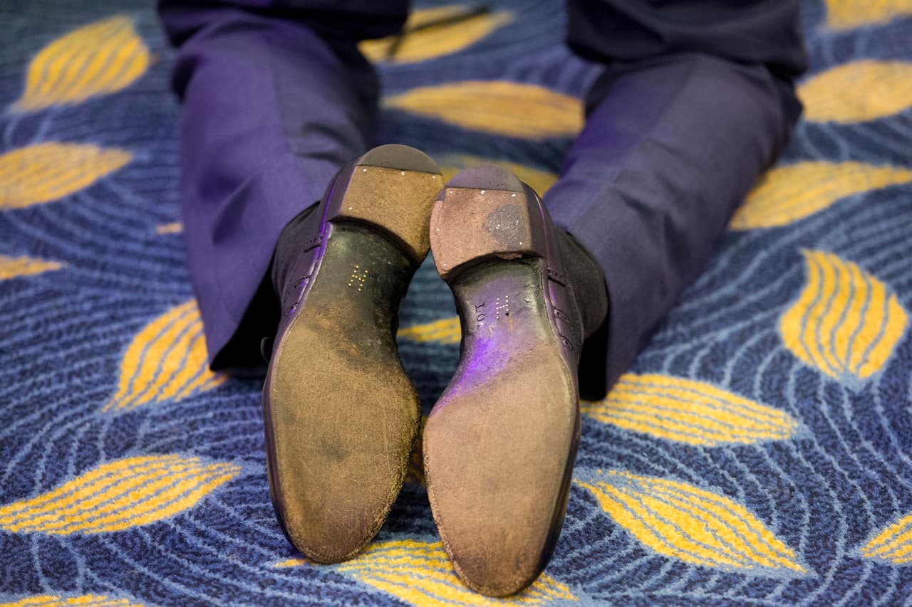 Al arrodillarse, notamos algo extraño en sus zapatos.