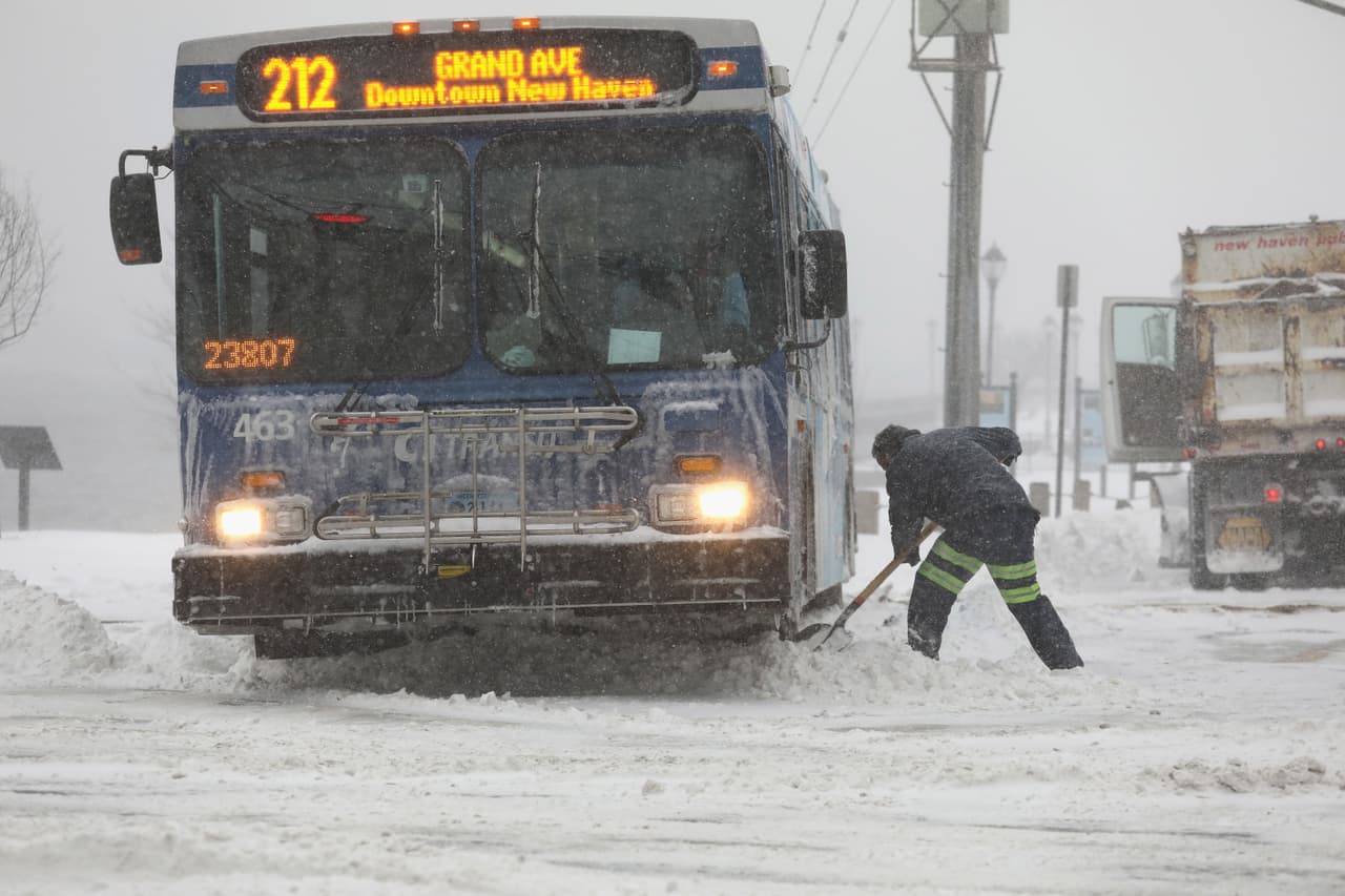 Un trabajador de la ciudad despeja la nieve bajo un autobús en New Haven, Connecticut.