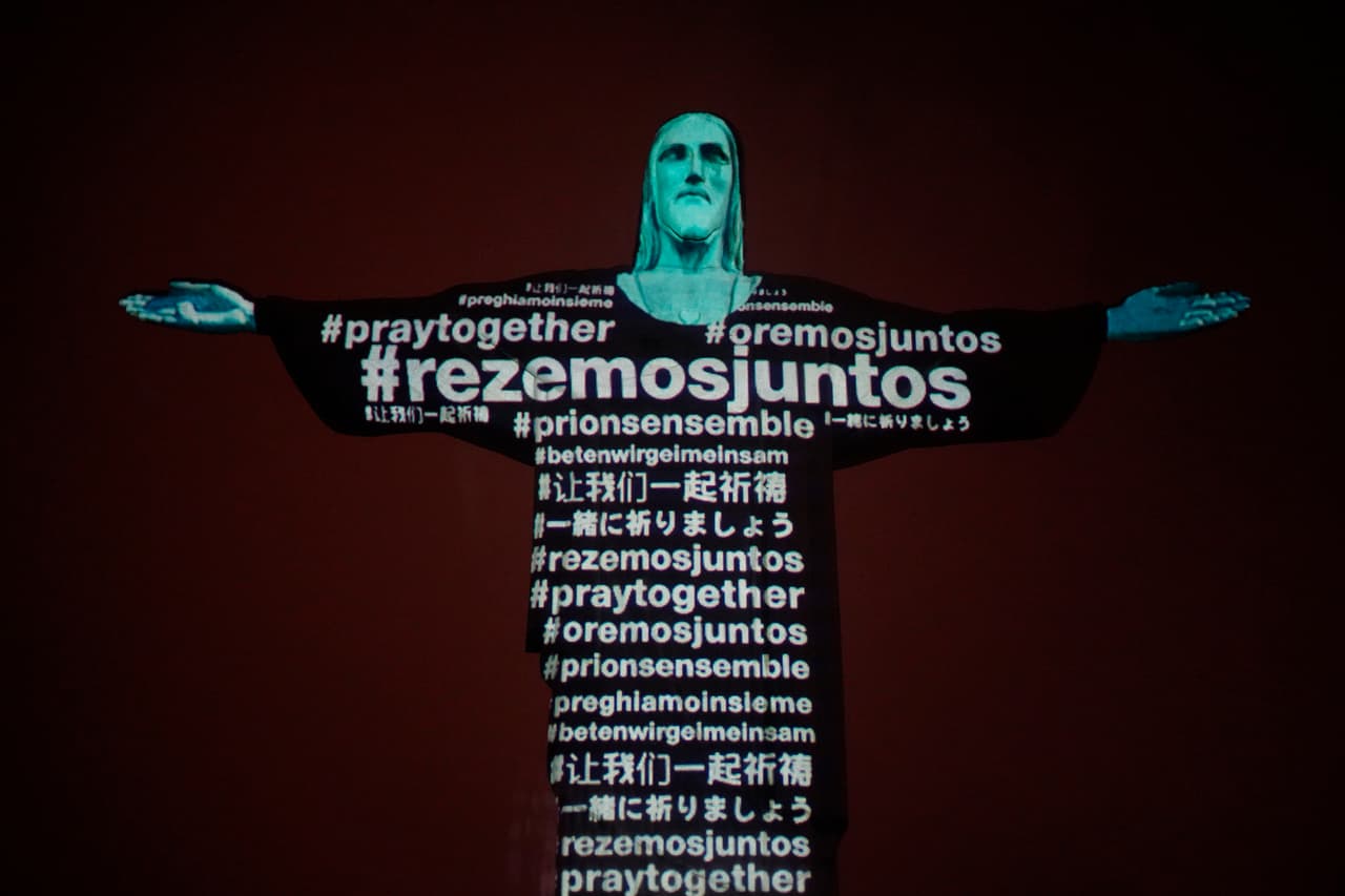 <b>“Recemos juntos”</b>, escrito en varios idiomas. Esta frase fue proyectada sobre el Cristo Redentor de Río de Janeiro cuando el arzobispo de la ciudad realizó una misa en honor de las víctimas de covid-19 en todo el mundo. 18 de marzo.