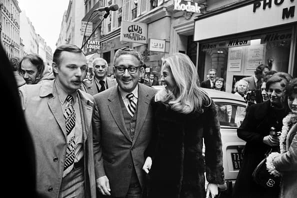 Kissinger y Jan Rose Cushing, esposa del banquero de inversiones estadounidense Frederick Cushing, saliendo del restaurante "Chez Tante Louise", cerca de la embajada estadounidense en París, el 21 de noviembre de 1972.