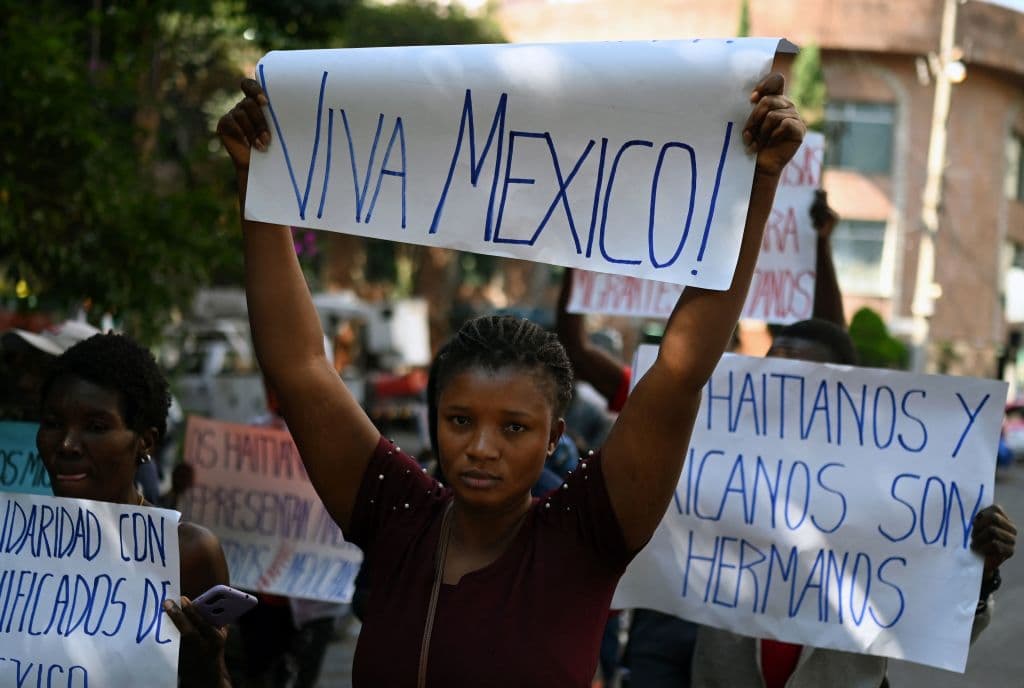Un grupo de migrantes haitianos sostiene pancartas durante una manifestación para exigir al gobierno mexicano visas humanitarias para poder trabajar y circular libremente, en la Ciudad de México, el 7 de noviembre de 2023.