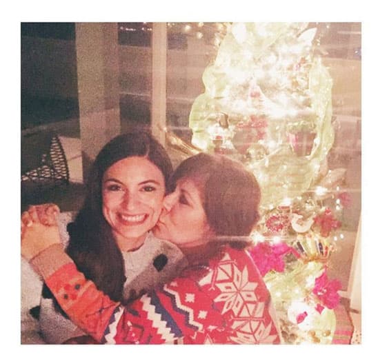 Ana Brenda Contreras recibe un beso de su mami frente al arbolito.