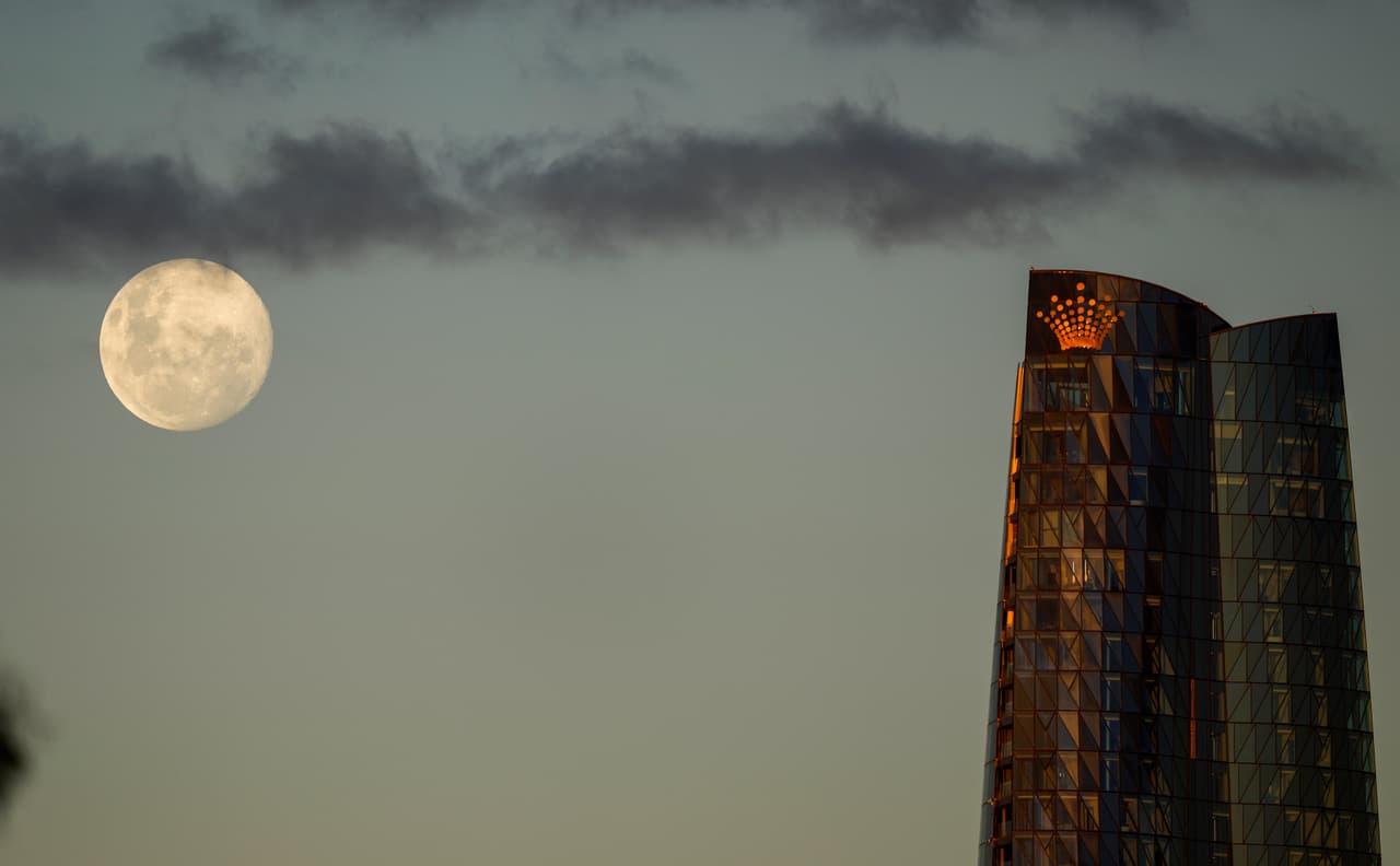 La luna emerge en el cielo de Sydney. Al lado se ve la torre Barangaroo.