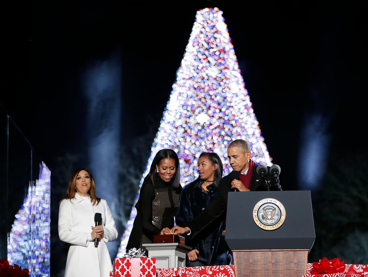 Los Obama presionando el botón que enciende las miles de luces multicolores que arropan el árbol de Navidad. (Foto de Alex Brandon/AP)